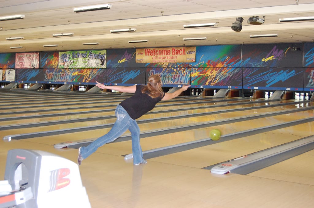 A Young Woman in Action at the Bowling Tournament
