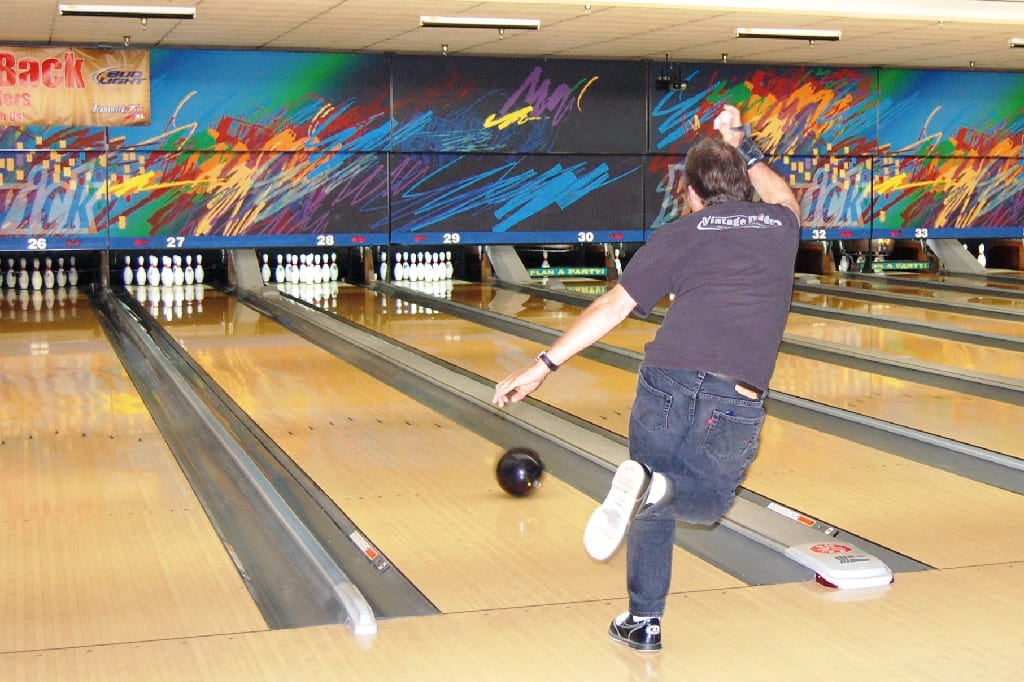 A Man Throwing Bowl and Full Sets at the Bowling Alley