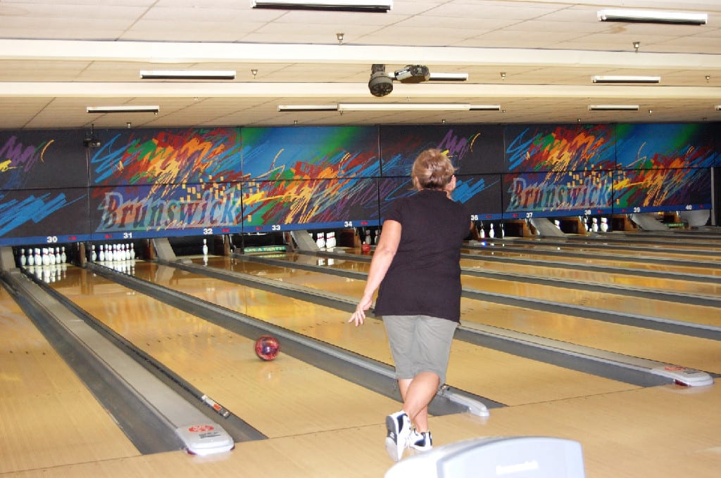 A Woman Throwing A Bowl at Brunswick Bowling Alley