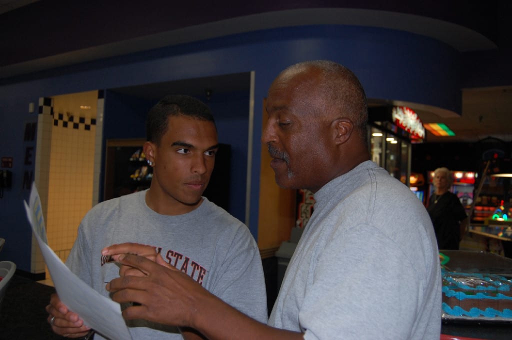 Two People Talking and Holding a Paper at the Bowling Alley in Brunswick