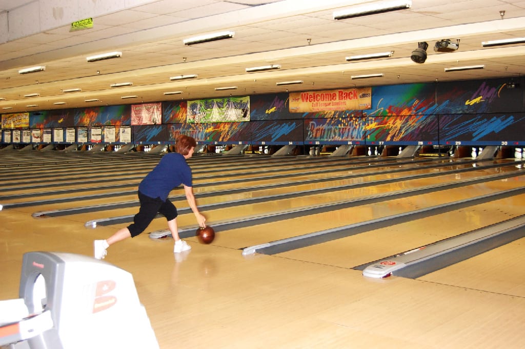 A Woman with Bowl in Action During Annual Bowling Tournament