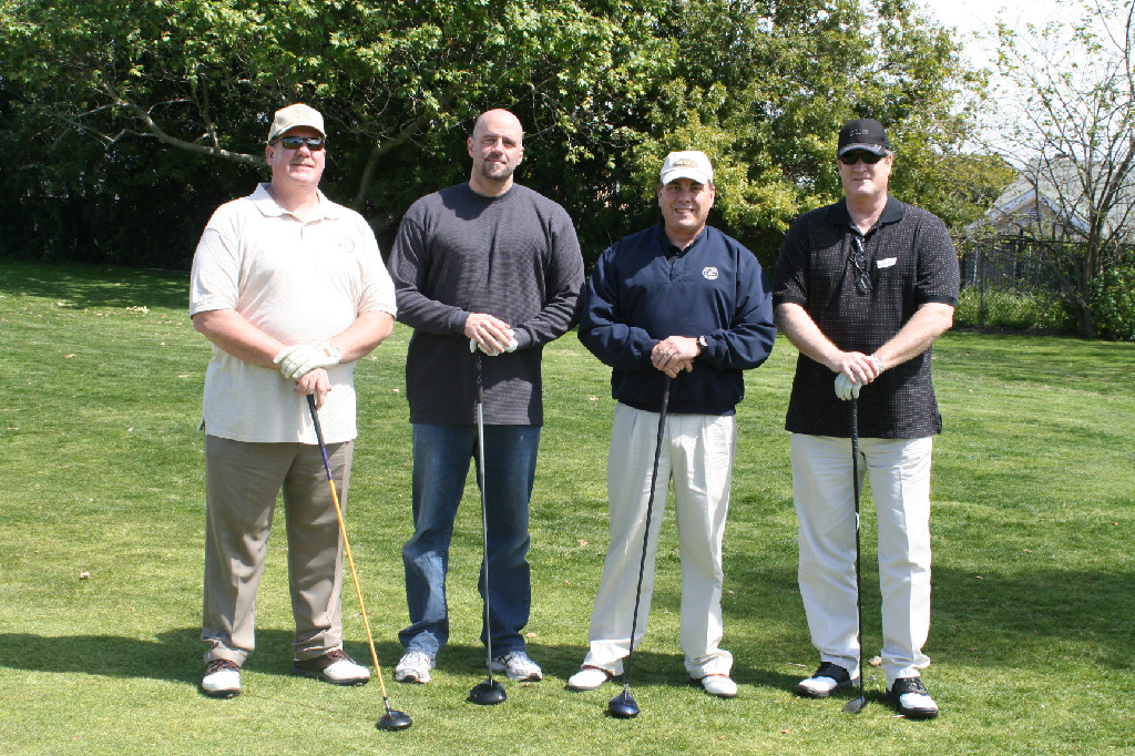 Four Participants of Annual Golf Tournament Posing for the Photo Session