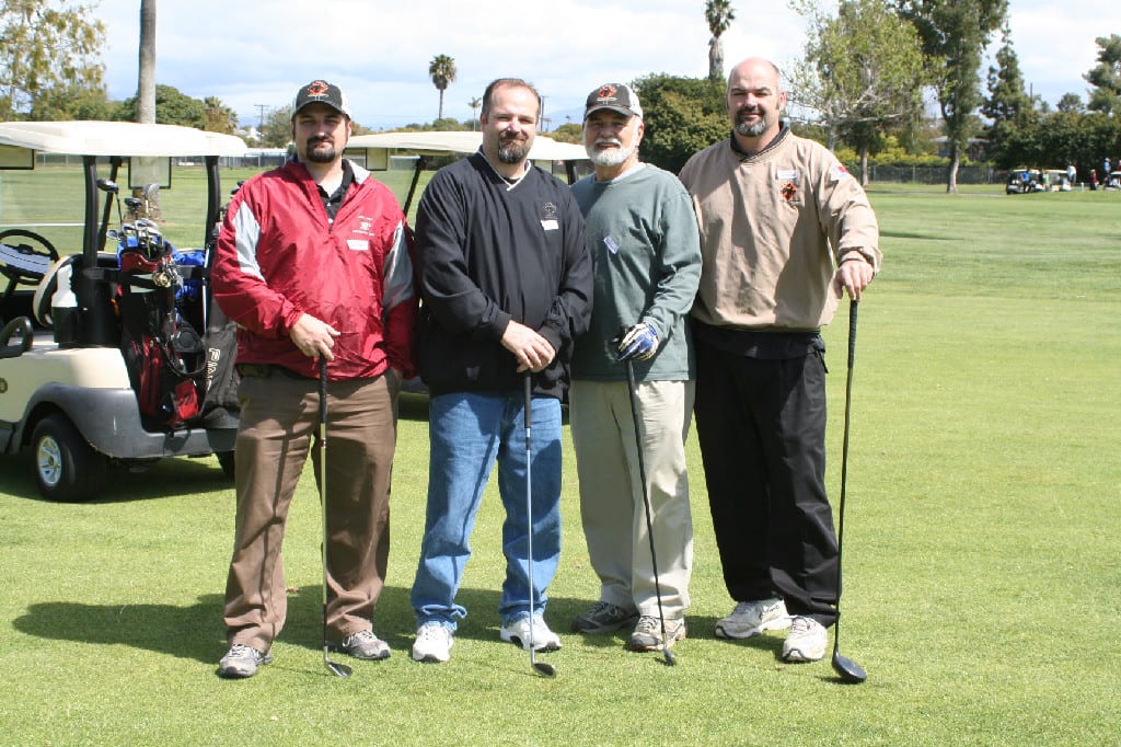 Four Golfers in Winter Garments with Clubs and Carts