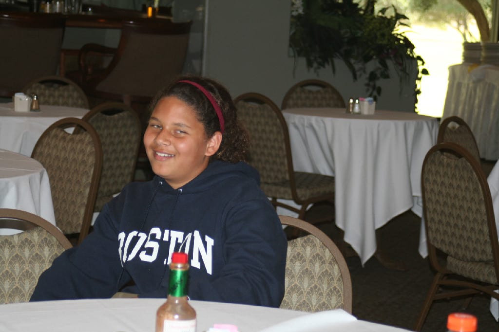 A Young Golf Player Sitting with Chairs and Tables Around