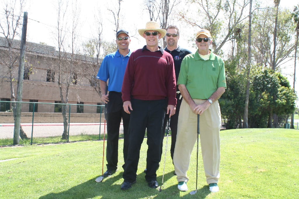 Four Golfers at Golf Course with A Building in the Back