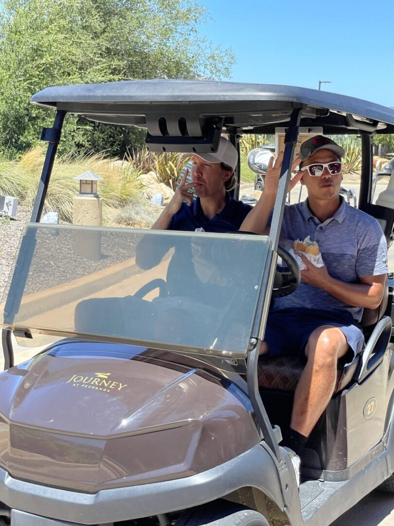 Two Young Golfers Enjoying Snacks Time on Golf Cart
