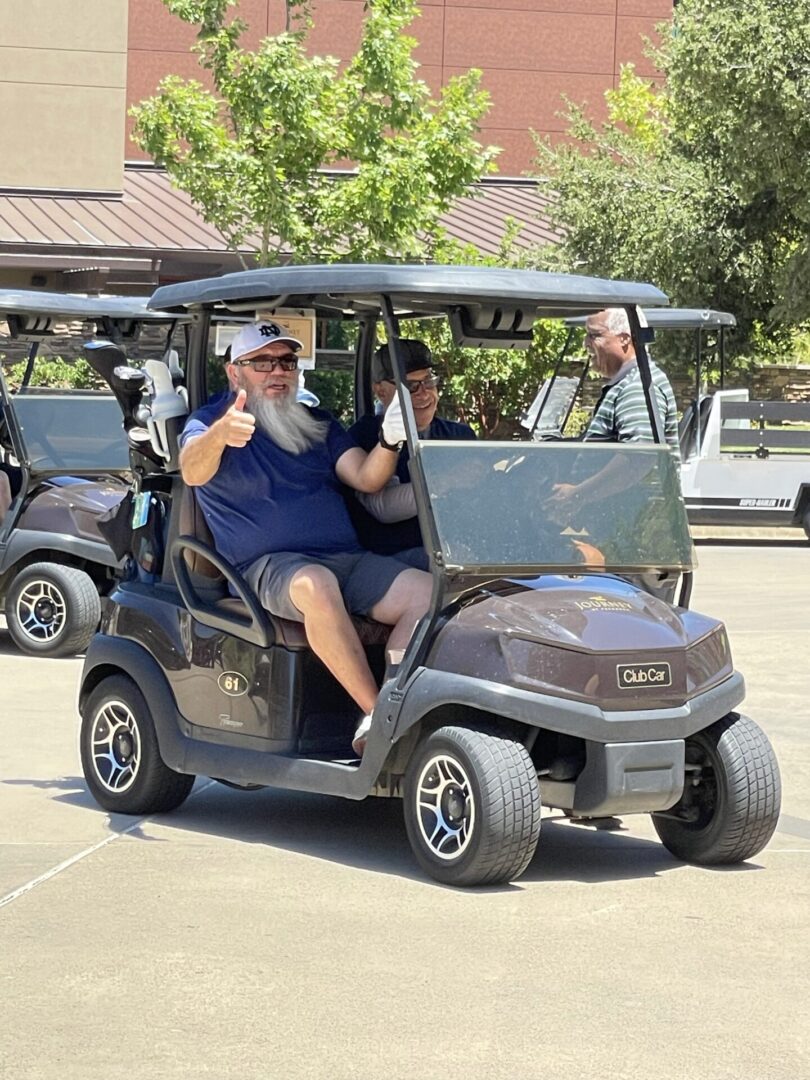 A Man with White Beard Thumbs Up White Sitting in a Golf Cart