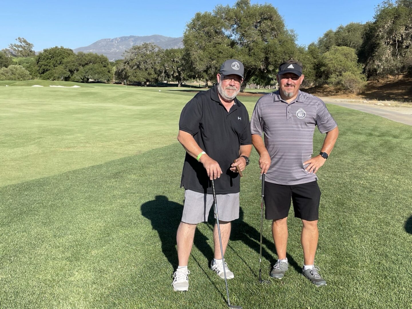 Two Golfers Standing on the Golf Course Holding Cubs