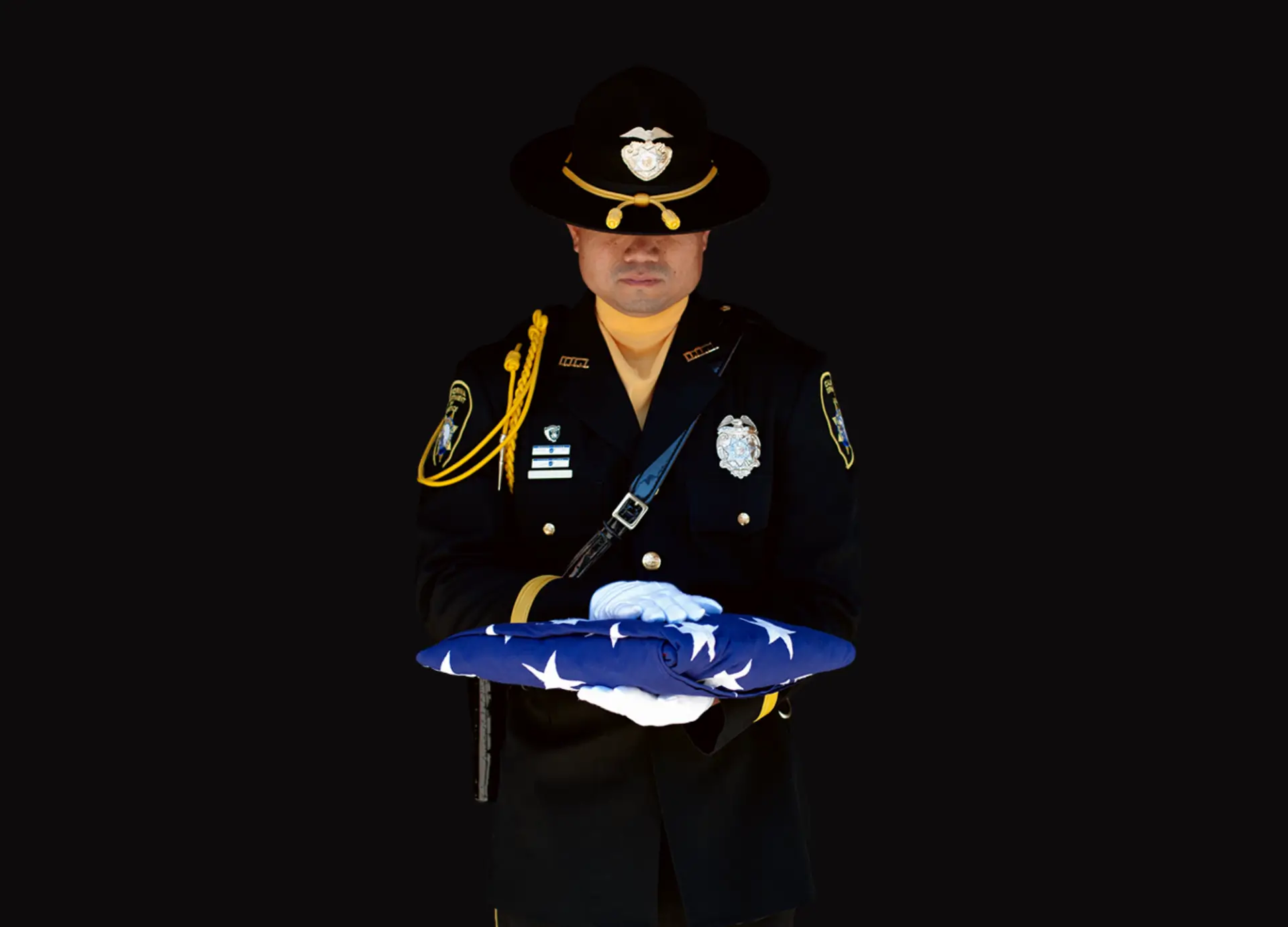 Officer holding a folded American flag.